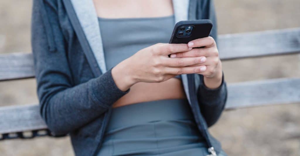 anonymous-woman-in-sportswear-browsing-smartphone-1