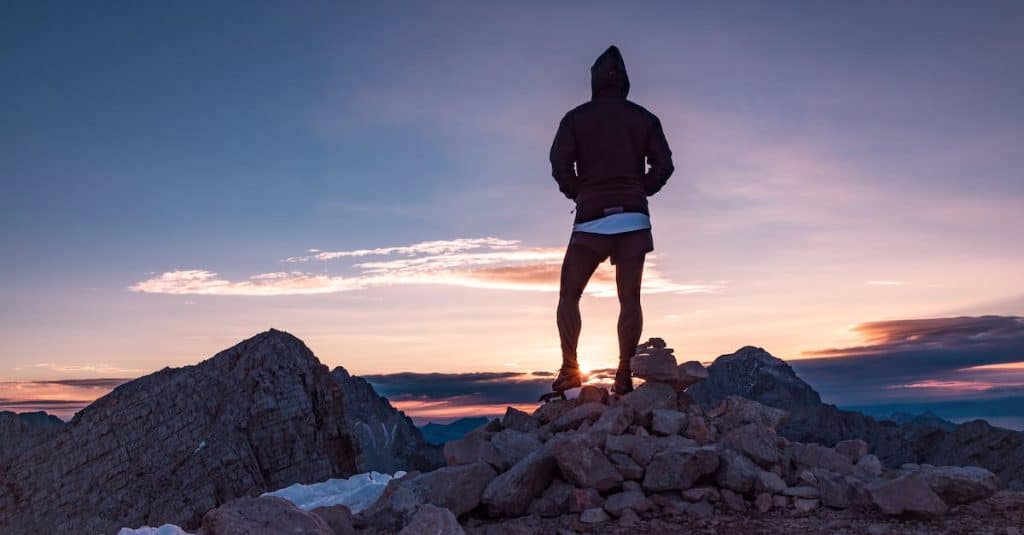 person-standing-on-rock-formation-during-golden-hour